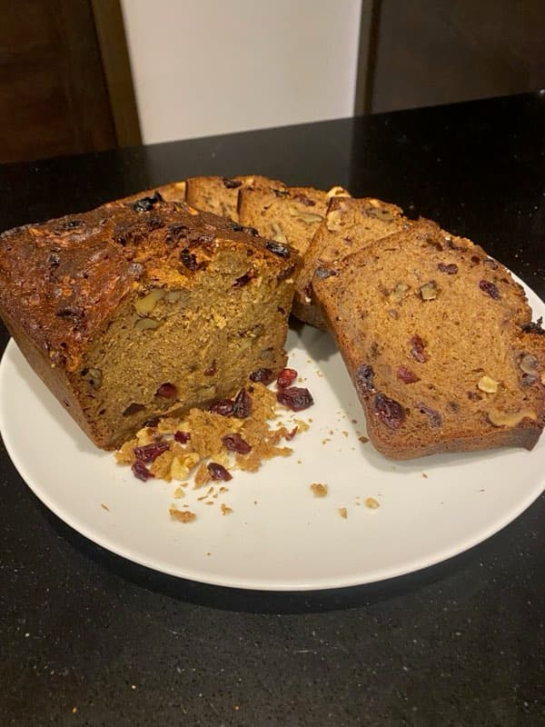 Sliced cranberry and walnut loaf, whole berries showing through the crumb