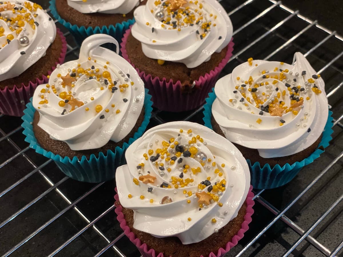 Chocolate cupcakes with vanilla frosting and gold sprinkles