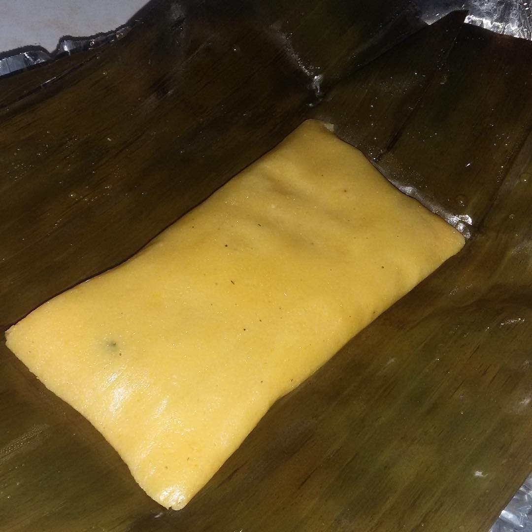 A soft yellow cornmeal pastelle unwrapped on its banana leaf