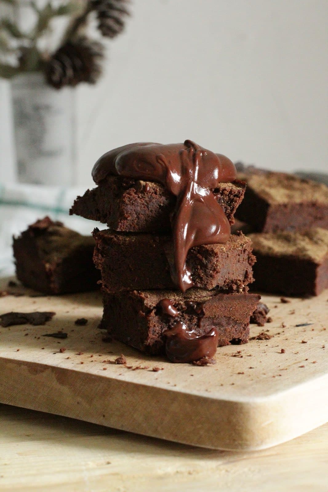 A stack of fudgy chocolate brownies with melted chocolate on top