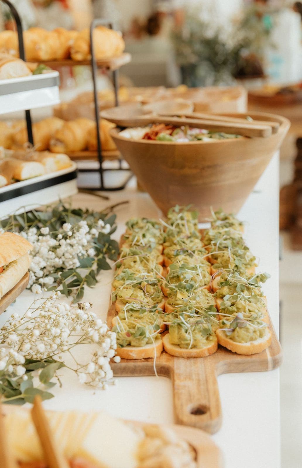 A long grazing table laid with sweet bakes, fruit and flowers
