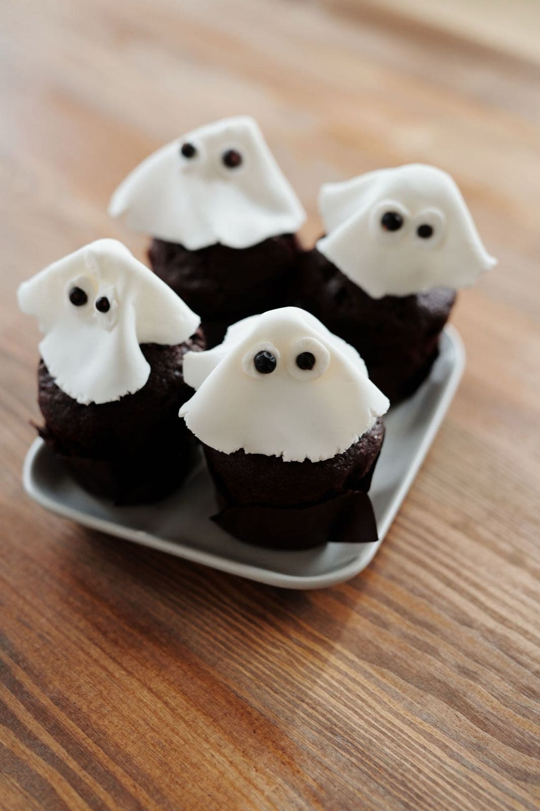 Chocolate cupcakes topped with white ghost decorations