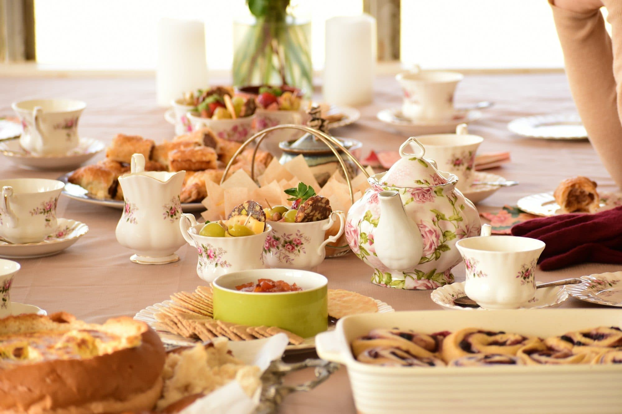 A table set for afternoon tea with sandwiches, pastries, cakes and teacups