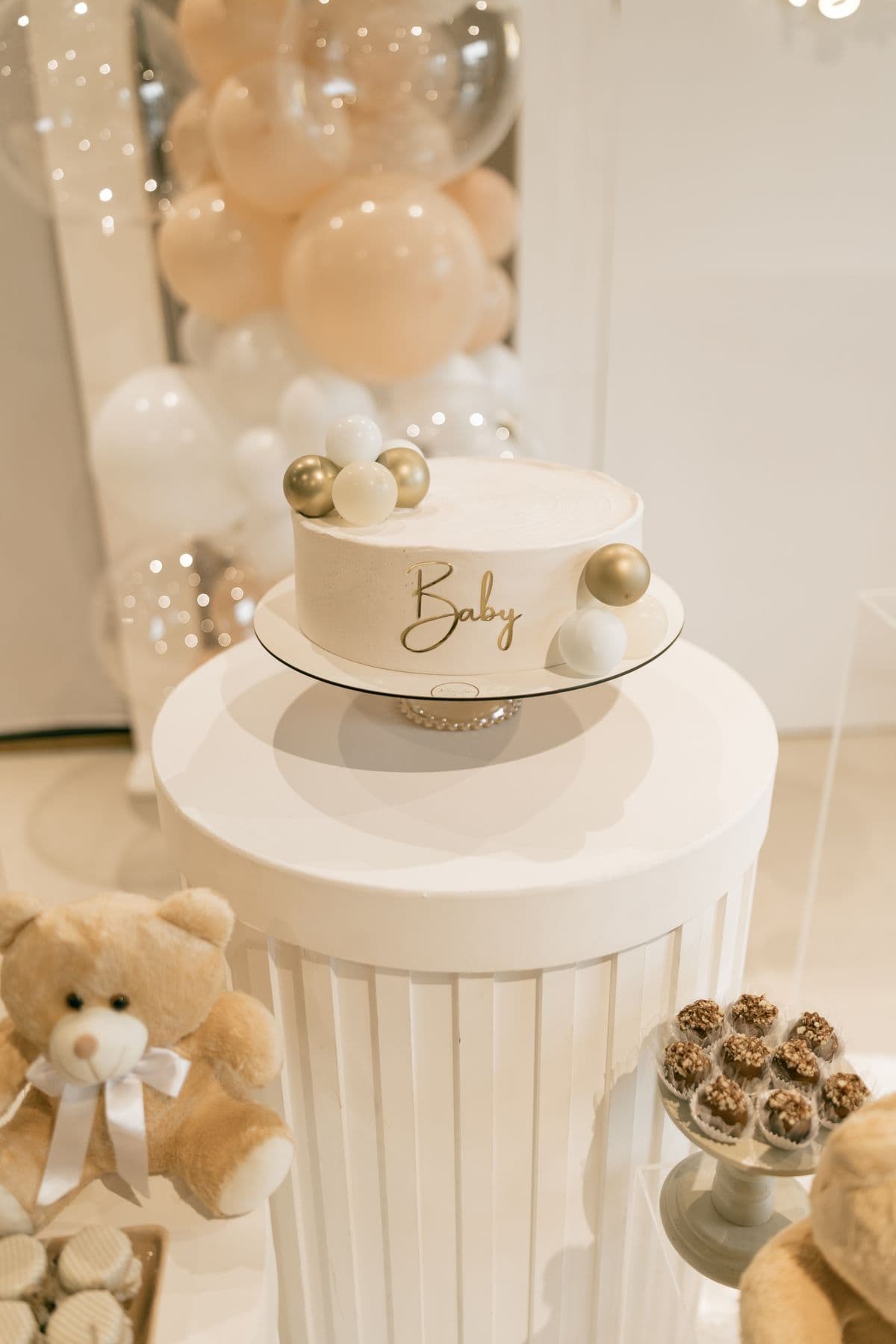 A soft-iced baby shower cake decorated with teddy bears and balloons