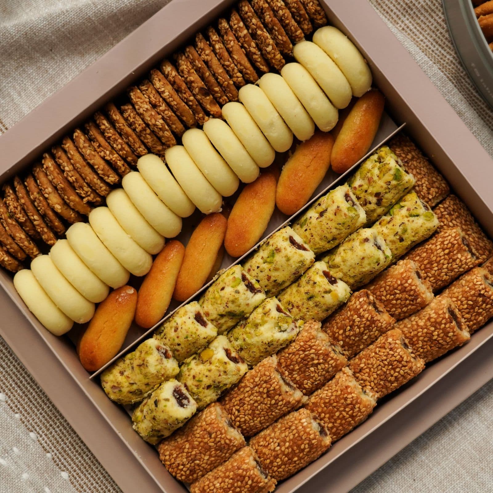 A flat gift box packed in neat rows with biscuits, slices and small bakes